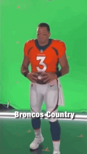 A Football Player Is Standing In Front Of A Green Screen Holding A Football And Saying `` Let 'S Ride '' . GIF