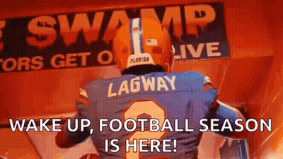 A Football Player Is Standing In Front Of A Sign That Says Wake Up , Football Season Is Here ! GIF