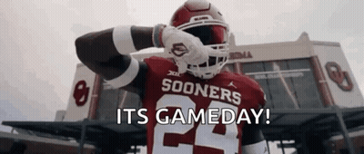 A Football Player Is Standing In Front Of A Stadium With The Words `` Its Gameday '' Written On The Screen . GIF