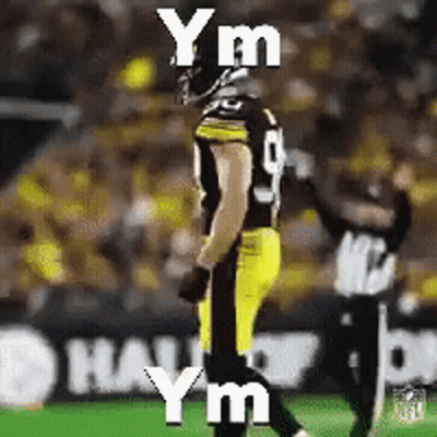 A Football Player Is Standing On A Field With The Words Y M Y M Y M Written On It GIF