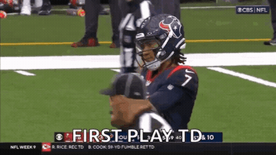 A Football Player Is Standing On The Field With A Referee . GIF