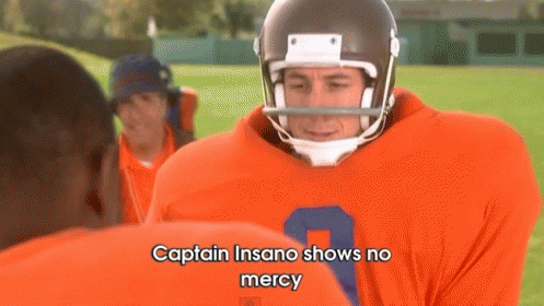 A Football Player Is Talking To Another Player On A Field . GIF