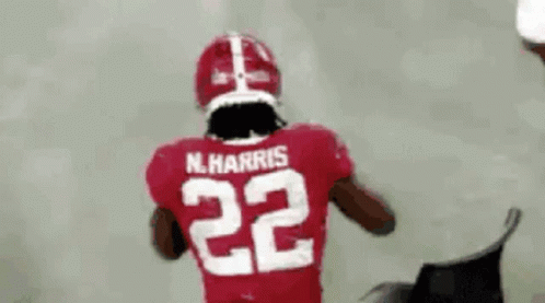 A Football Player Is Wearing A Red Jersey With The Number 22 On The Back . GIF