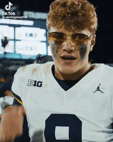 A Football Player Is Wearing Sunglasses And A Big Shirt GIF
