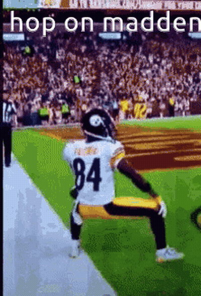 A Football Player Kneeling On The Field With The Number 84 On His Jersey . GIF