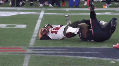 A Football Player Laying On The Field With The Number 21 On His Jersey GIF