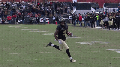 A Football Player Running On The Field With The Number 45 On His Jersey GIF