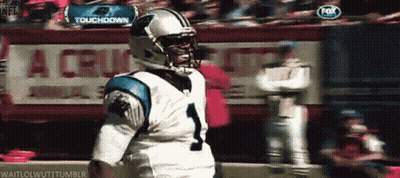 A Football Player Stands In Front Of A Sign That Says " Touchdown " GIF