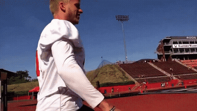 A Football Player Stands In Front Of A Stadium That Says Eastern Warriors On It GIF