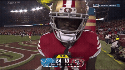 A Football Player Wearing A 49Ers Helmet Stands In Front Of A Scoreboard GIF