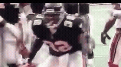 A Football Player Wearing A Black Jersey With The Number 32 On It Is Standing On A Field . GIF