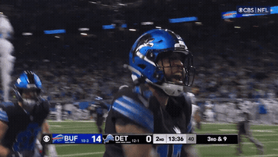 A Football Player Wearing A Blue Helmet Stands On The Field GIF