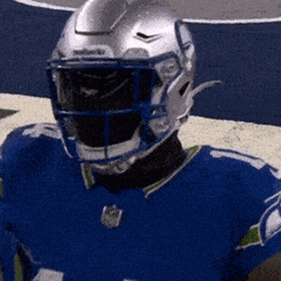 A Football Player Wearing A Blue Jersey And A Helmet GIF
