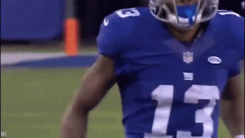 A Football Player Wearing A Blue Jersey With The Number 13 On It Is Standing On A Field . GIF