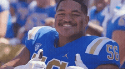 A Football Player Wearing A Blue Jersey With The Number 50 On It Is Smiling At The Camera . GIF