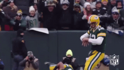 A Football Player Wearing A Green And Yellow Uniform With The Number 12 On It GIF