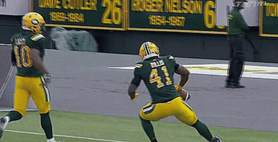 A Football Player Wearing A Green Jersey With The Number 41 On It Is Running With A Ball . GIF