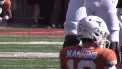 A Football Player Wearing A Helmet And A Jersey With The Name Manning On It Is Kneeling On The Field . GIF