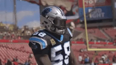 A Football Player Wearing A Helmet And A Number 50 Jersey Is Standing On A Field . GIF