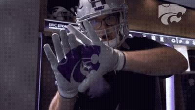 A Football Player Wearing A Helmet And Gloves With The Letter H On It . GIF