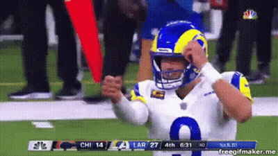 A Football Player Wearing A Helmet Is Standing On The Field . GIF