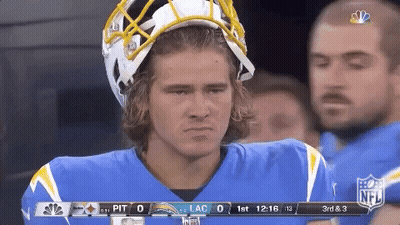 A Football Player Wearing A Helmet Stands On The Sidelines GIF