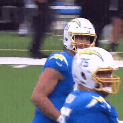 A Football Player Wearing A Helmet With The Number 15 On It Stands Next To Another Player GIF
