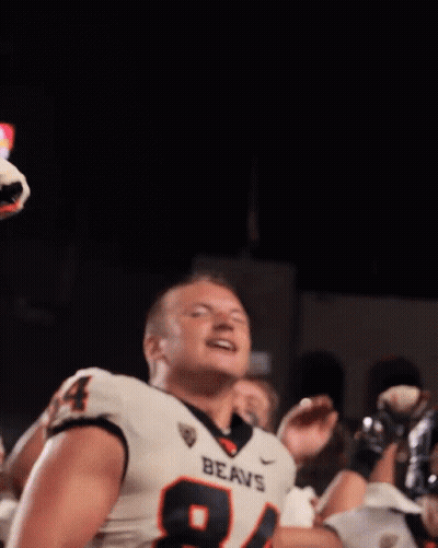 A Football Player Wearing A Jersey That Says Beavs Stands In Front Of A Crowd GIF