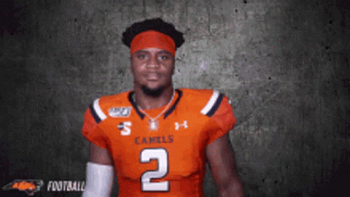 A Football Player Wearing A Jersey That Says Camels On It GIF