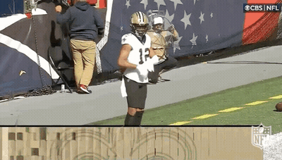 A Football Player Wearing A Jersey With The Number 12 On It Is Standing On The Field . GIF