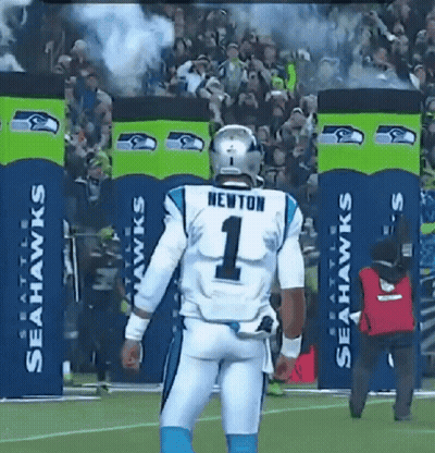 A Football Player Wearing A Number 1 Jersey Stands In Front Of Seahawks Banners GIF