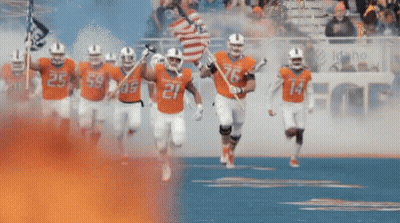 A Football Player Wearing A Number 14 Jersey Is Running On A Field . GIF