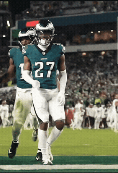 a football player wearing a number 27 jersey is running on the field