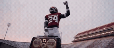 A Football Player Wearing A Number 29 Jersey Is Standing On Top Of A Boombox In A Stadium . GIF