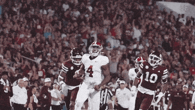 A Football Player Wearing A Number 4 Jersey Is Running With The Ball GIF