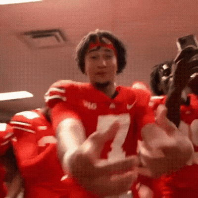 A Football Player Wearing A Number 7 Jersey Is Hugging Another Player . GIF