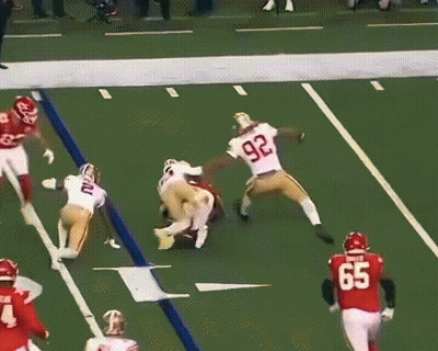 A Football Player Wearing A Number 97 Jersey Is Being Tackled By Another Player GIF