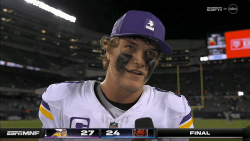 A Football Player Wearing A Purple Hat And A Jersey With The Letter C On It GIF