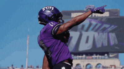 A Football Player Wearing A Purple Jersey With Tcu On The Front GIF
