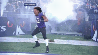 A Football Player Wearing A Purple Jersey With The Number 12 On It GIF