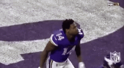 A Football Player Wearing A Purple Jersey With The Number 14 On It Is Jumping In The Air . GIF