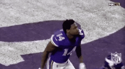 A Football Player Wearing A Purple Jersey With The Number 14 On It Is Running On The Field . GIF