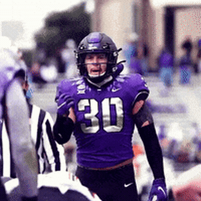 A Football Player Wearing A Purple Uniform With The Number 30 On It GIF