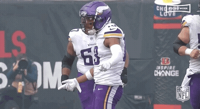 A Football Player Wearing A Purple Uniform With The Number 68 On It GIF