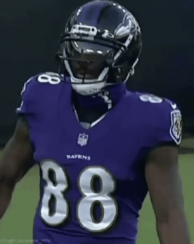 A Football Player Wearing A Purple Uniform With The Number 86 On It GIF