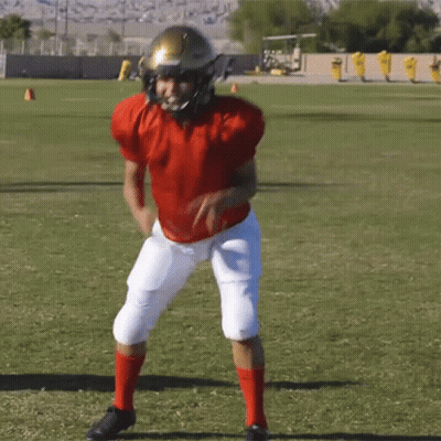 A Football Player Wearing A Red Jersey And White Pants Is Running On A Field GIF