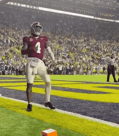 A Football Player Wearing A Red Jersey With The Number 4 On It Is Running On The Field . GIF