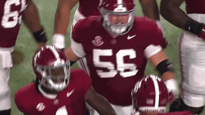 A Football Player Wearing A Red Jersey With The Number 55 On It Is Running On The Field . GIF