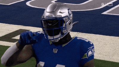 A Football Player Wearing A Seahawks Jersey And Helmet GIF