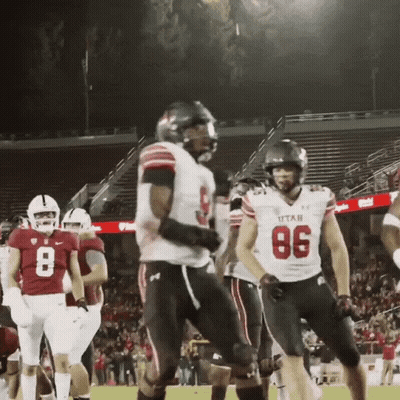 a football player wearing a utah jersey stands on the field